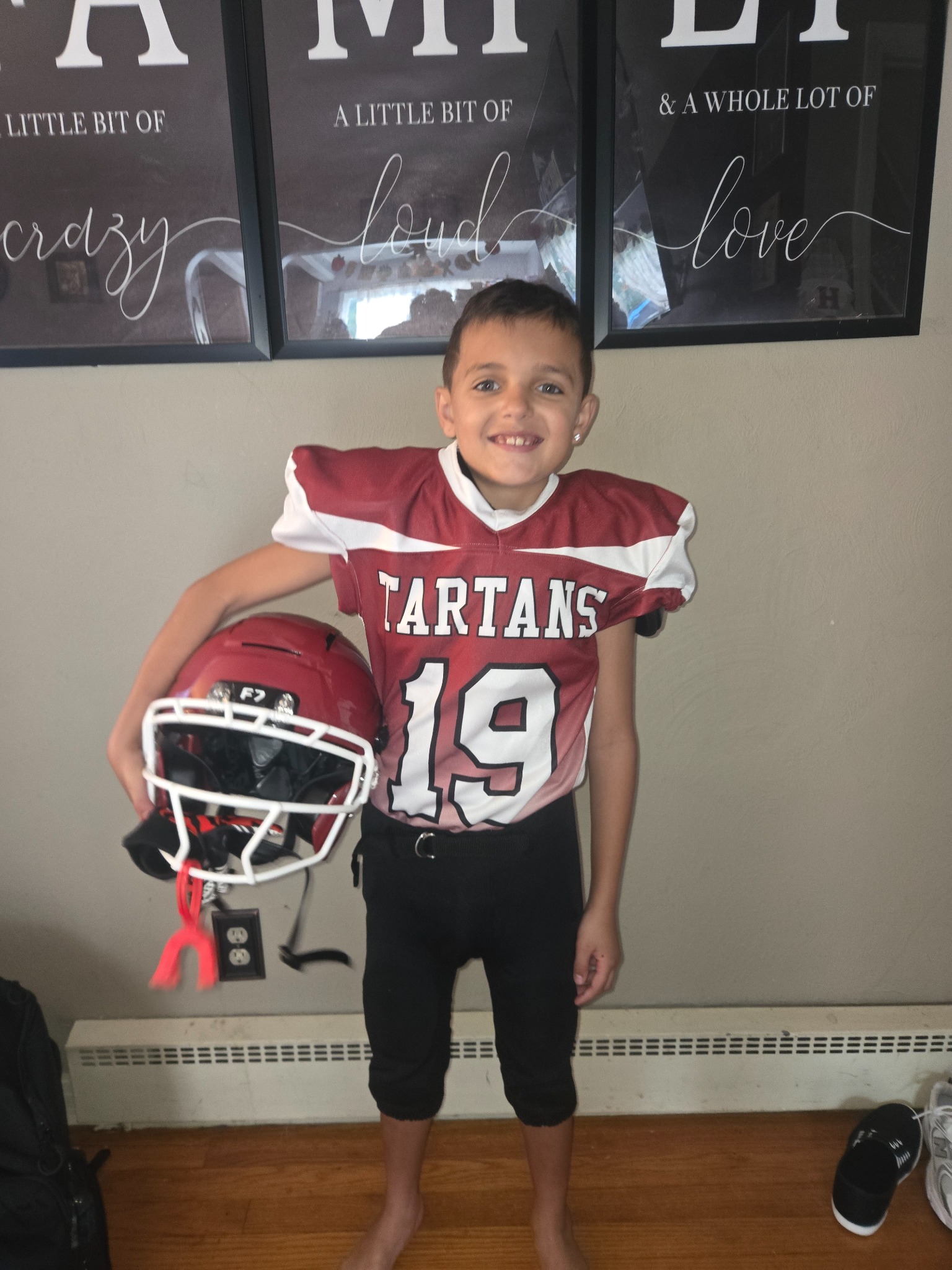 Tartans number 19 youth football uniform, front, holding helmet