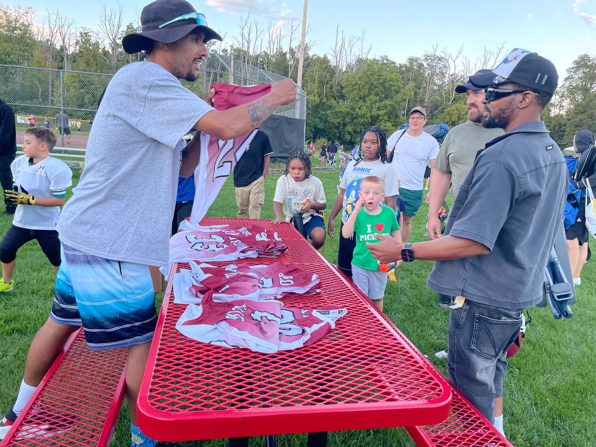 Community jersey handout at a picnic table